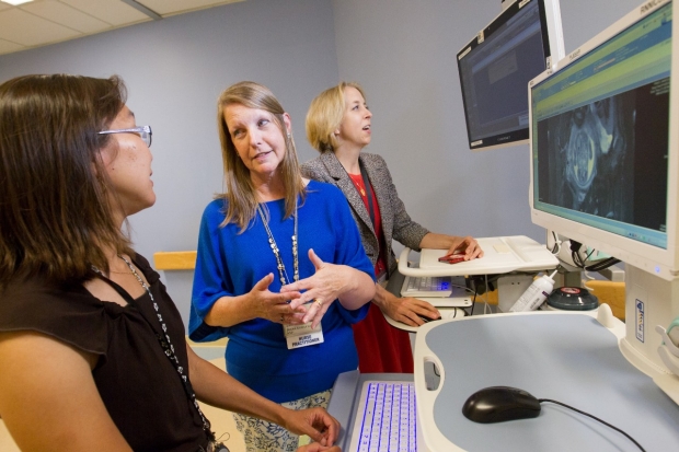 Dr. Valerie Chock talking to Neonatal Nurse Practitioner Diana Kobayashi while Dr. Susan Hintz looks at a computer screen