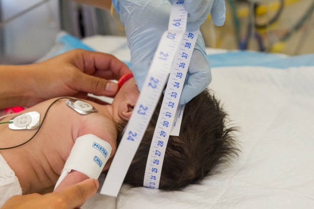 Neonate undergoing tests and measurements