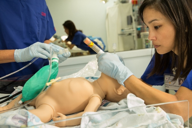 Neonatal Rescuscitation at CAPE - Dr. Nicole Yamada intubating an infant dummy.
