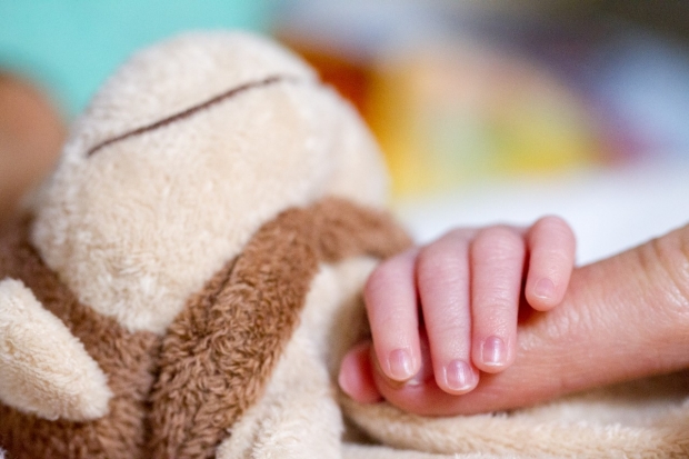 A newborn hand grasping mom
